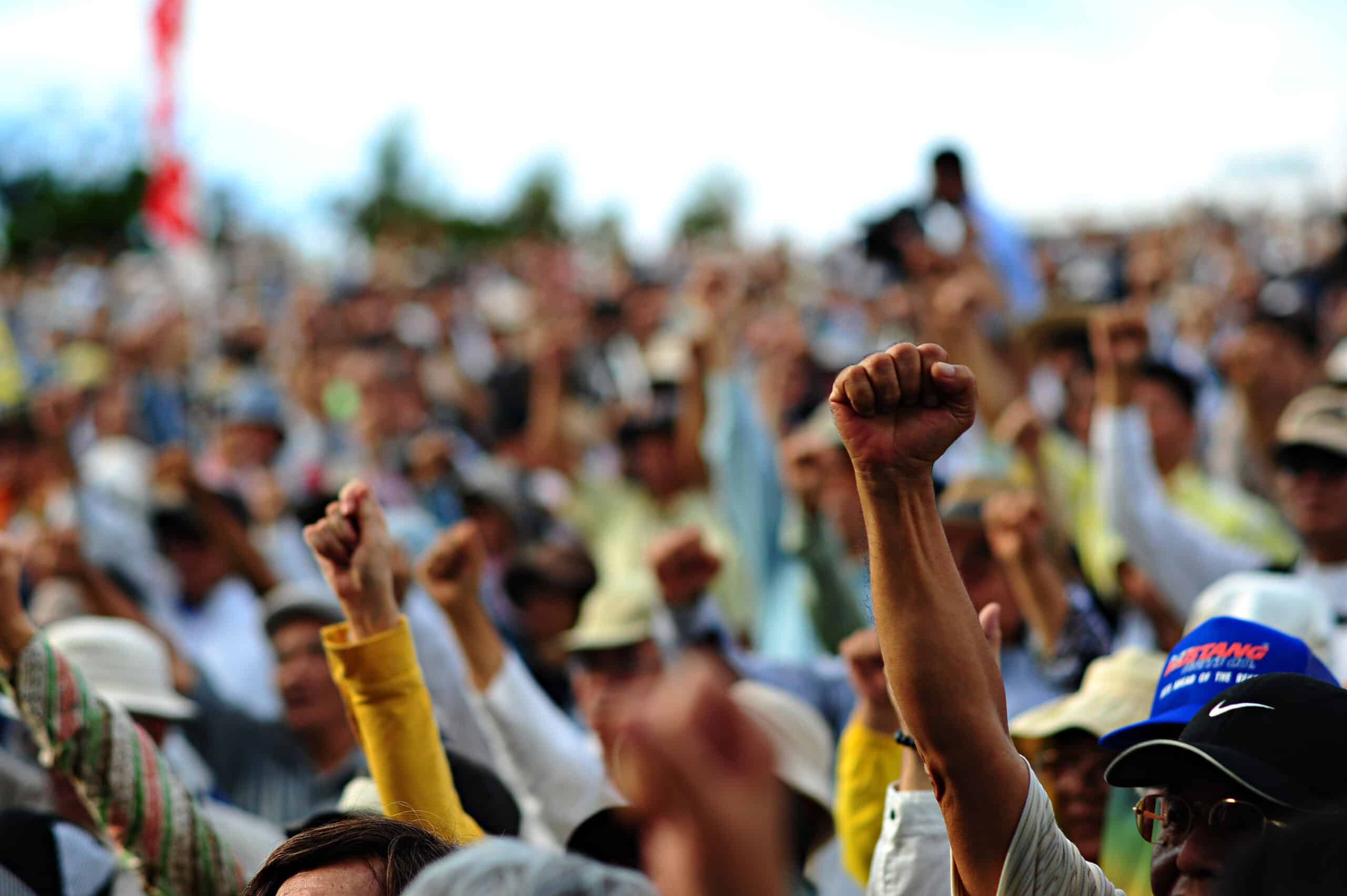 A picture of raised fists at a protest. (Credit: commons.wikipedia.org)